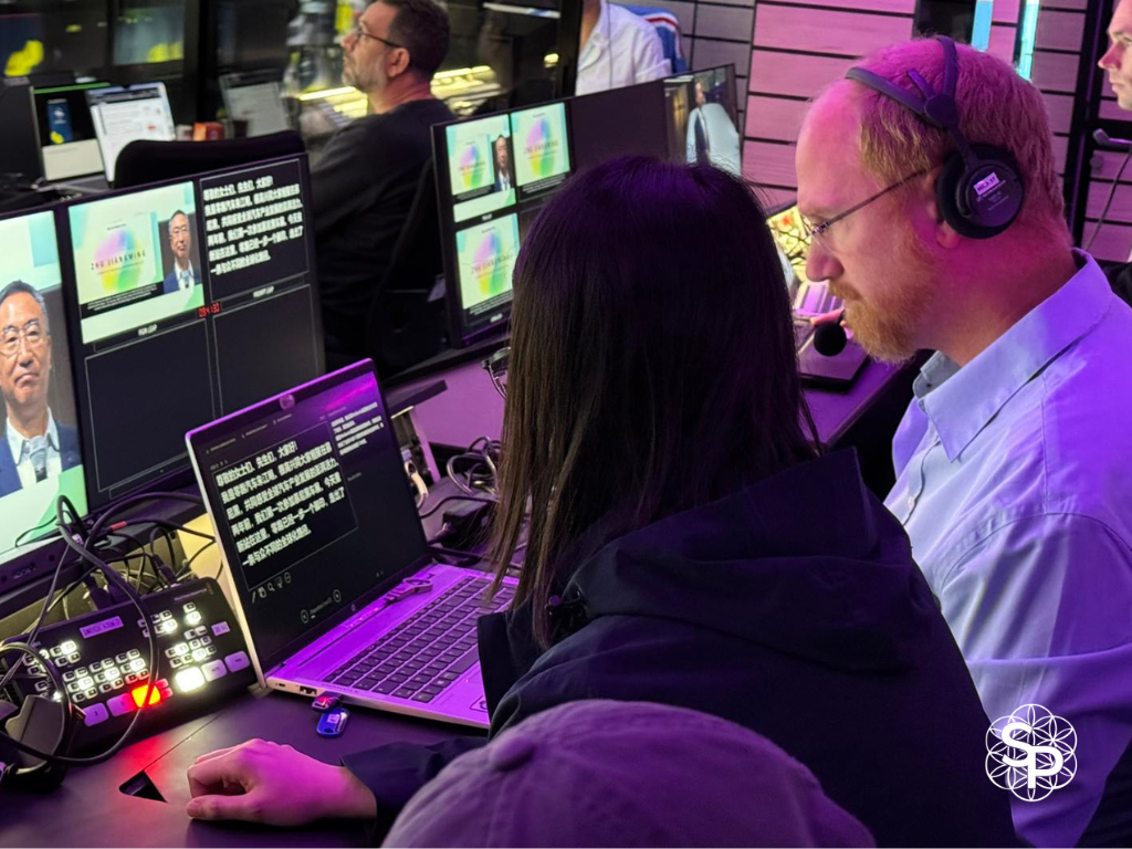 Deux techniciens prompteur très concentrés en régie vidéo, gérant le défilement d'un discours en direct.
